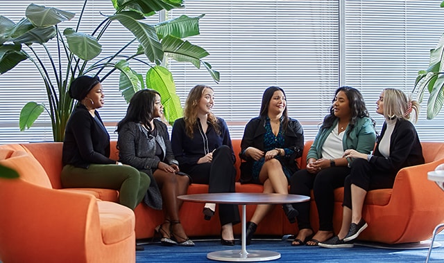 A group photo of six women in an office