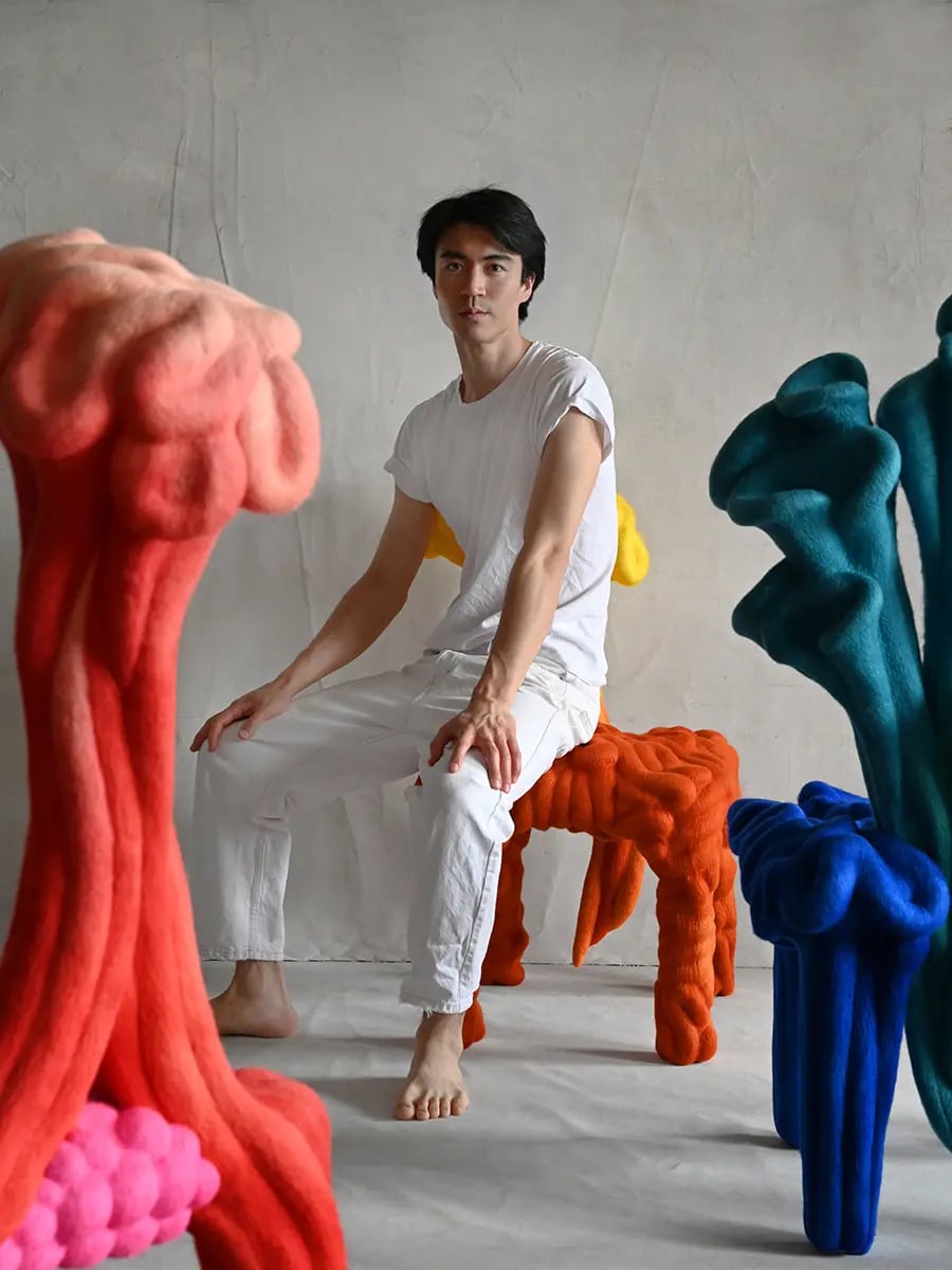 A man sitting among colourful sculptures