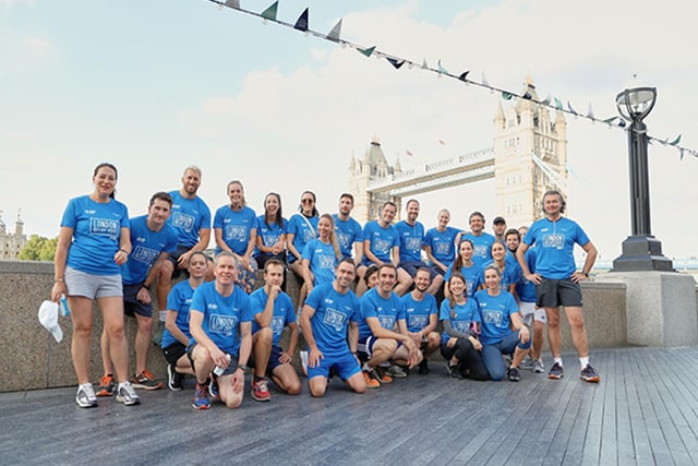A group photo of people in front of Tower Bridge in London