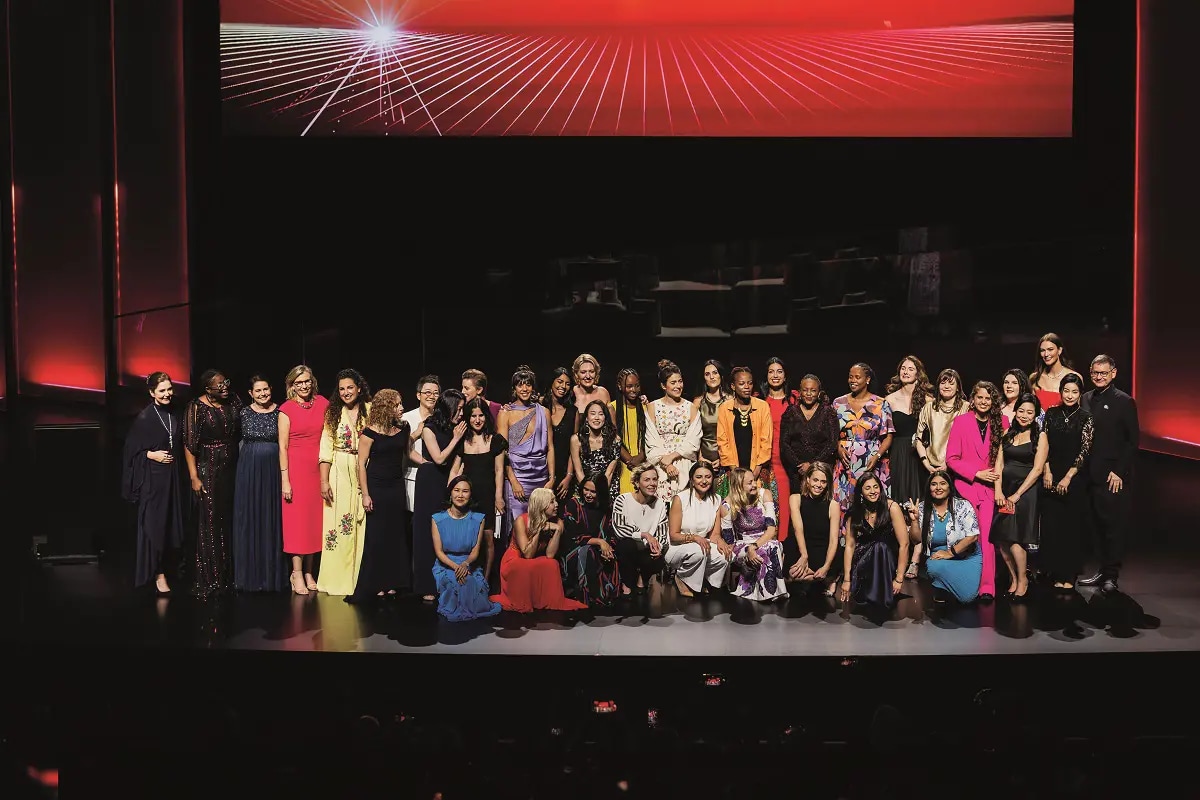 A group of elegantly dressed women on stage