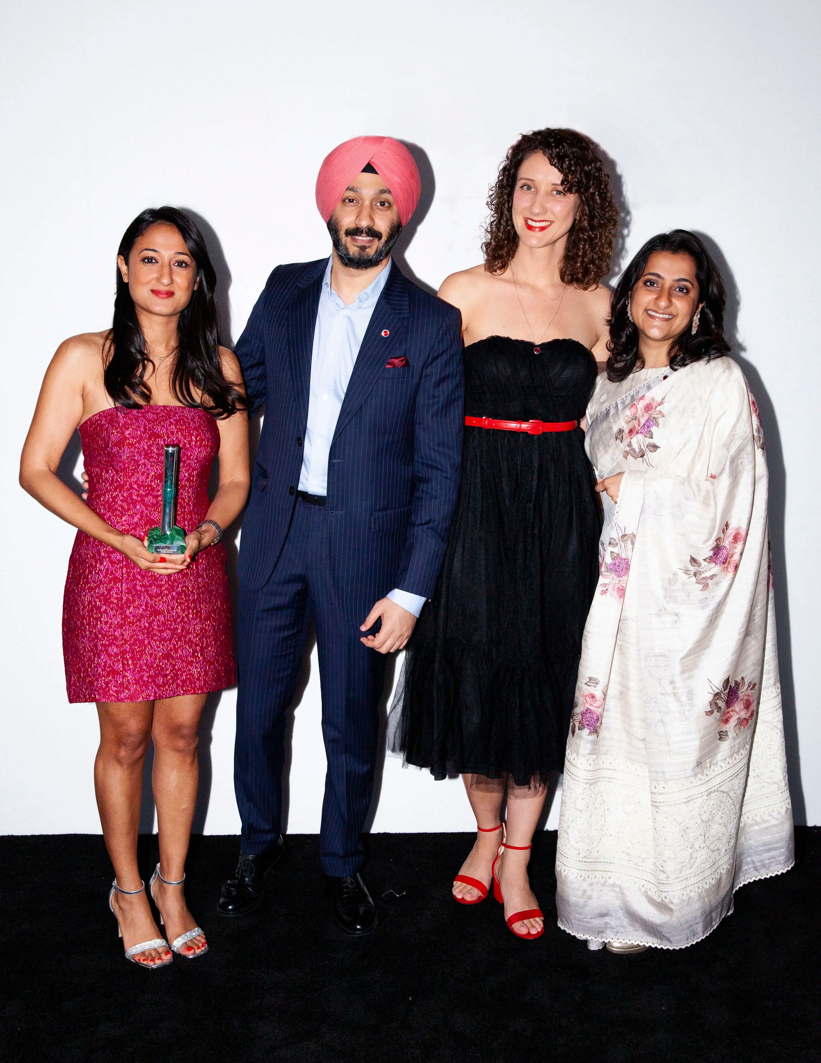 Dr Bea Bakshi with an award, posing with three other people